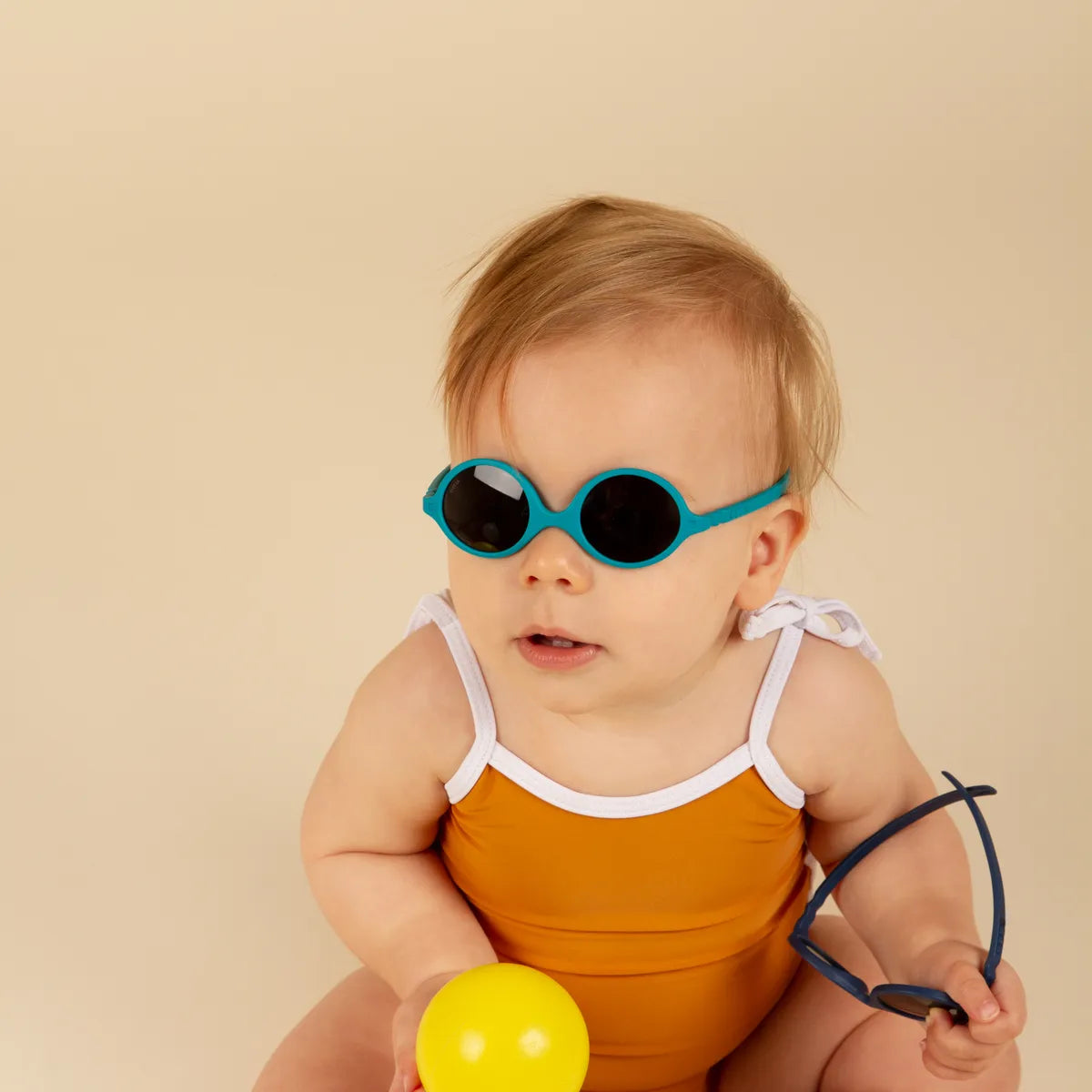 bébé blond avec lunette soleil bleu