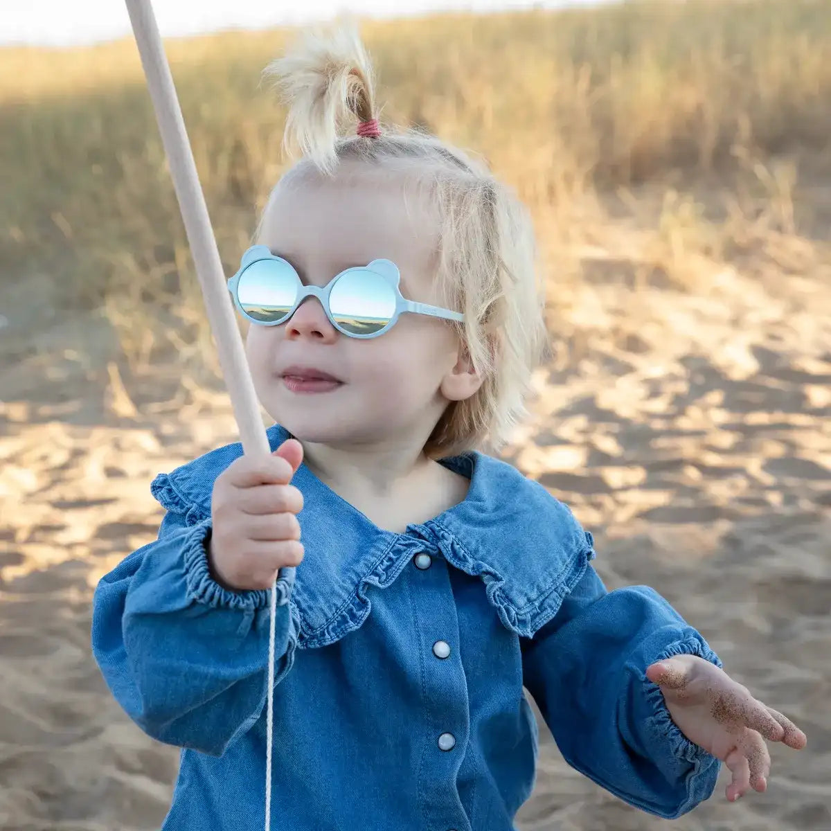 fille portant ourson bleu à la plage