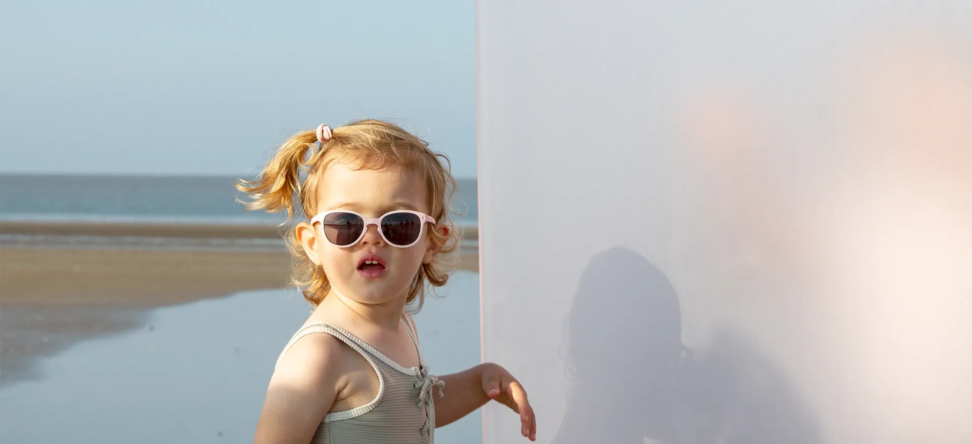 Fille à la plage avec lunette wazz rose
