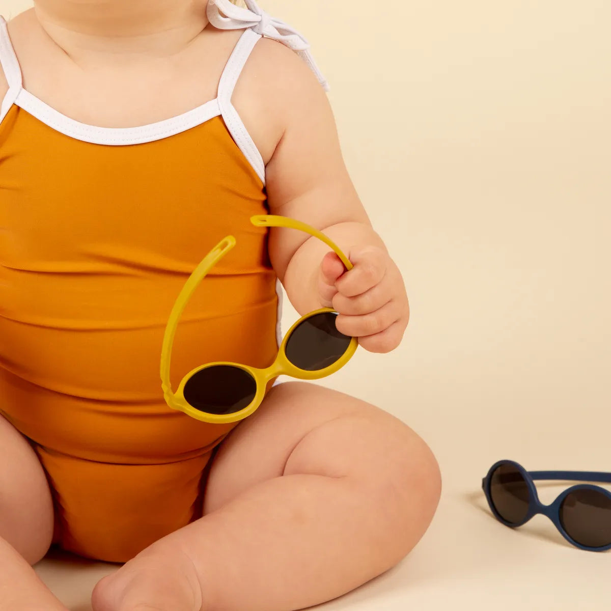 lunette diabola jaune dans la main de bébé