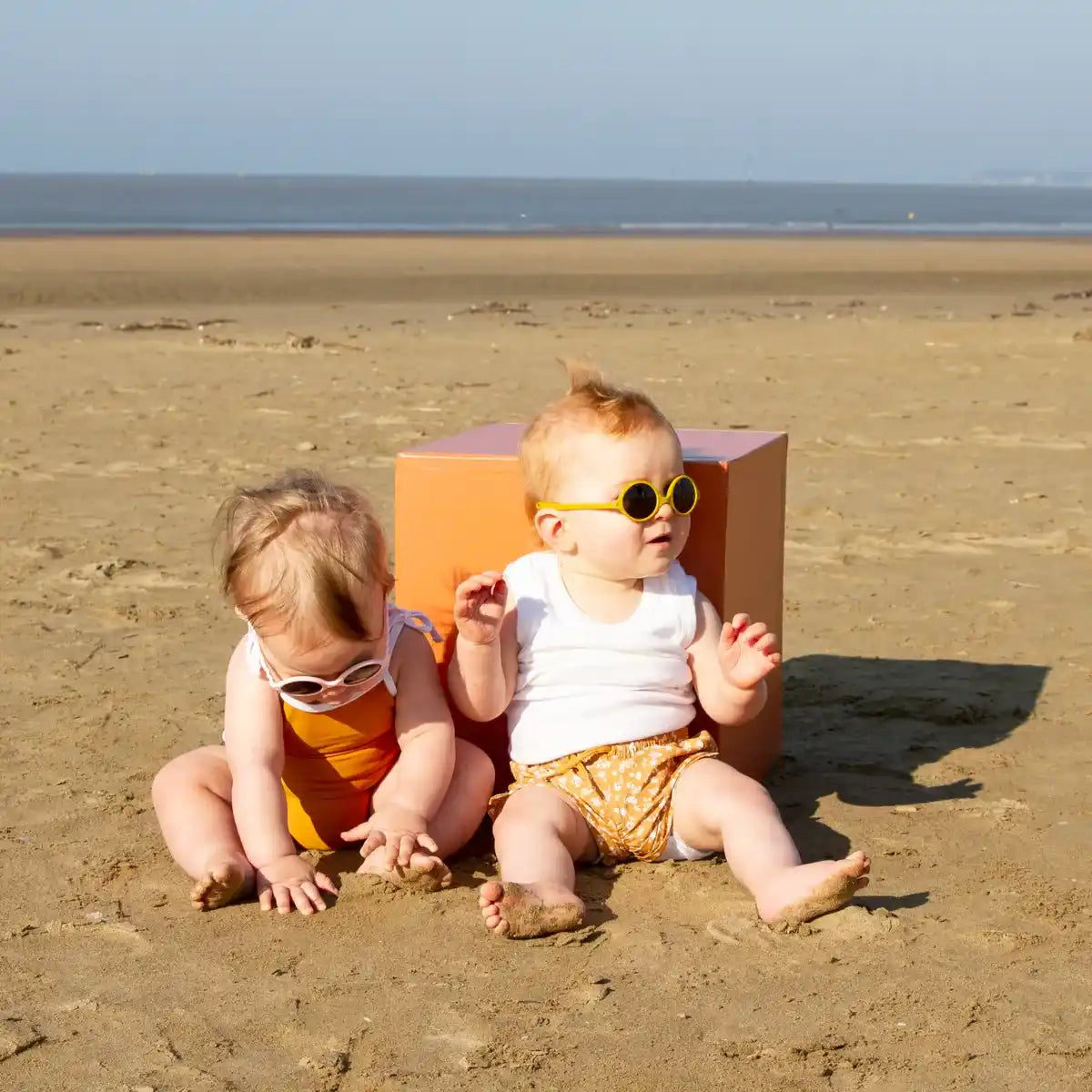 2 bébé à la plage avec lunettes soleil