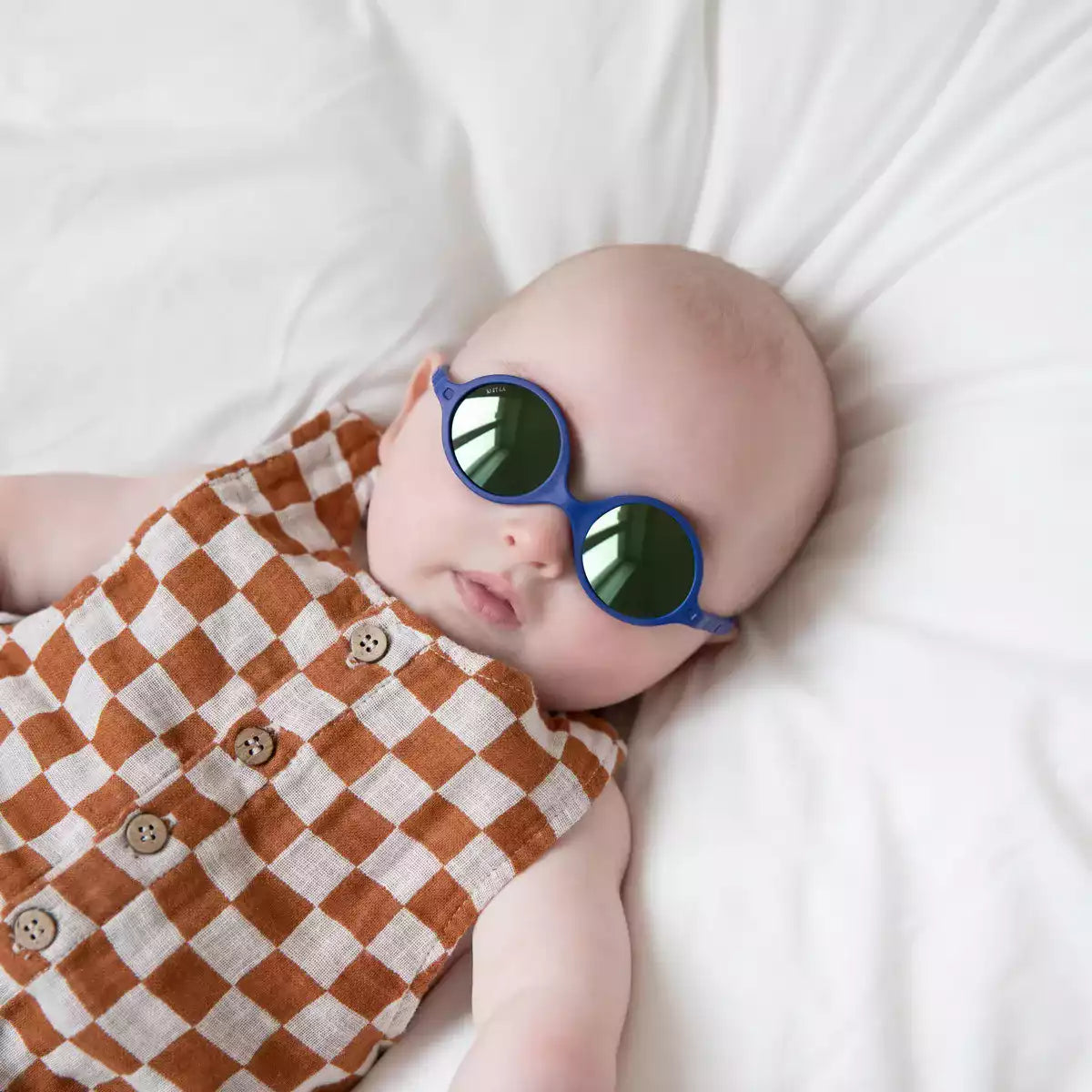 bébé portant lunette de soleil bleu