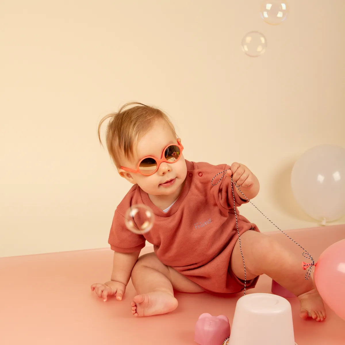 bébé jouant et portant lunette diabola