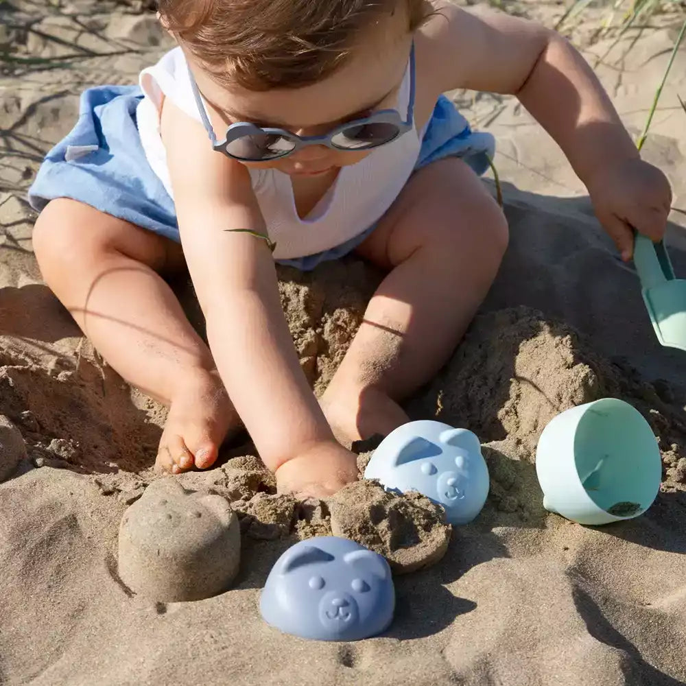 bébé faisant des pâtés de sable ourson