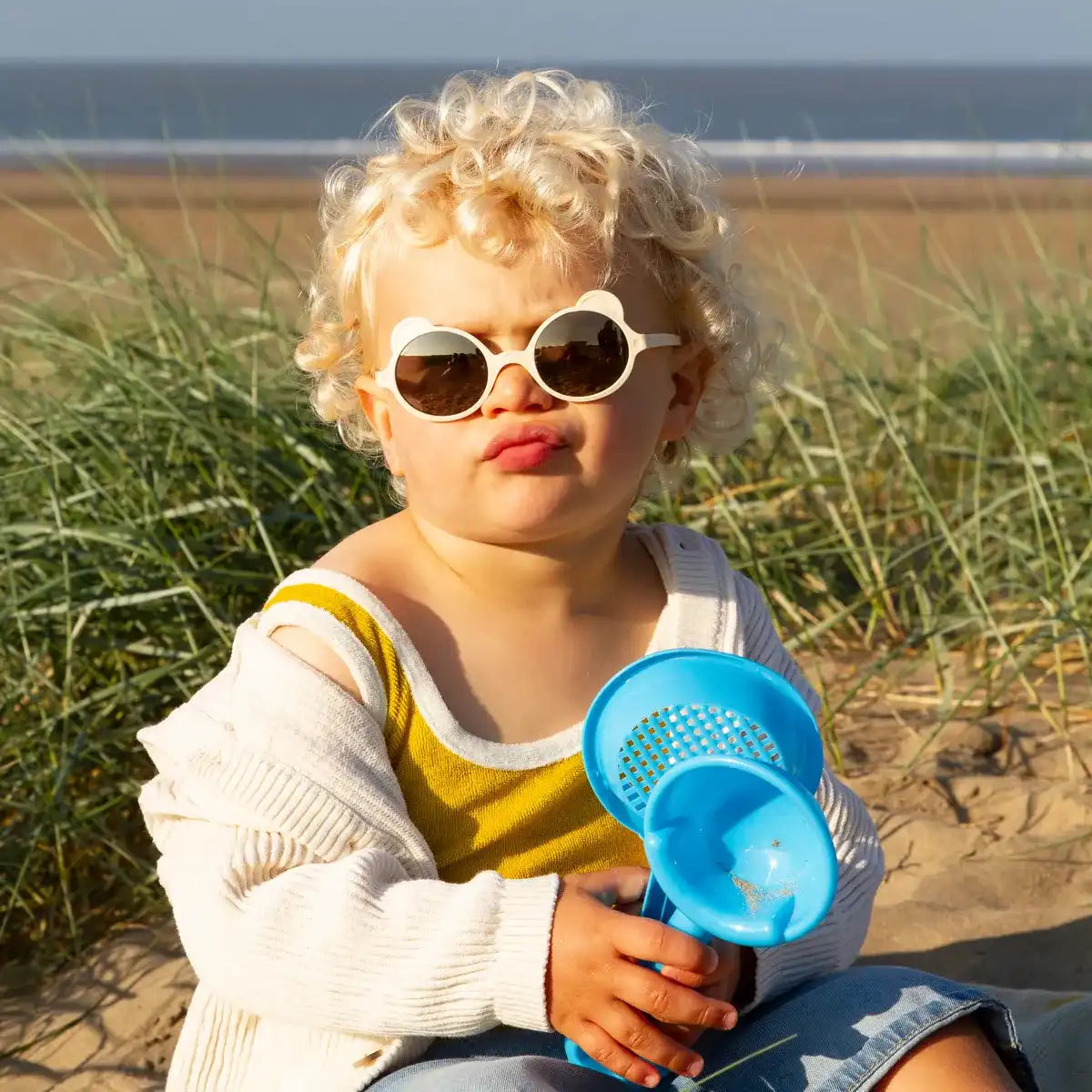 enfant portant lunette solaire ourson crème