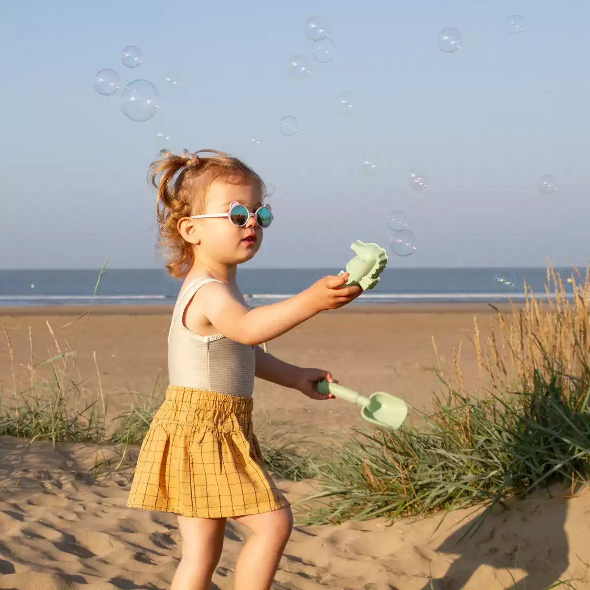 Fille sur sable avec lunettes ourson