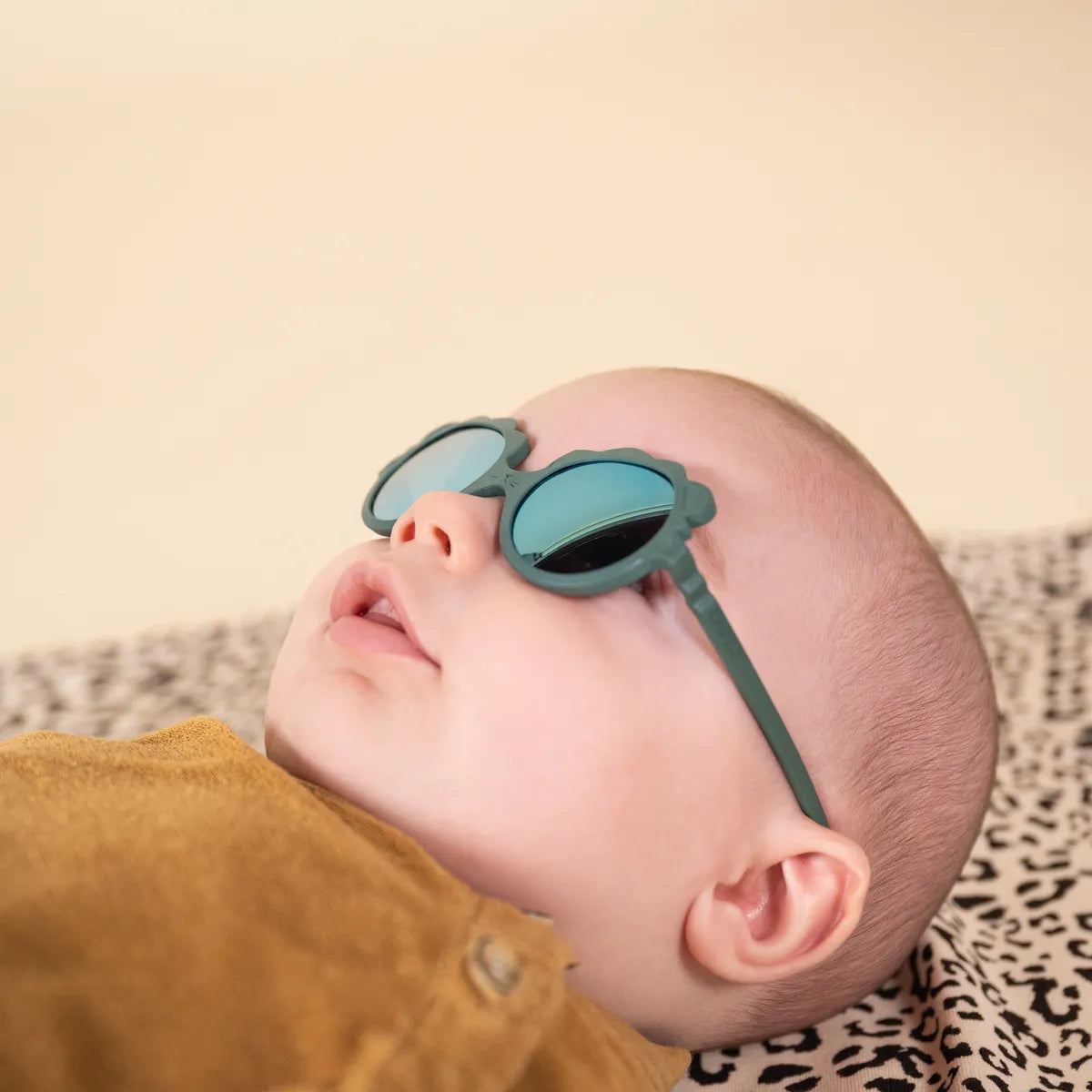 Bébé portant lunette de soleil lion vert