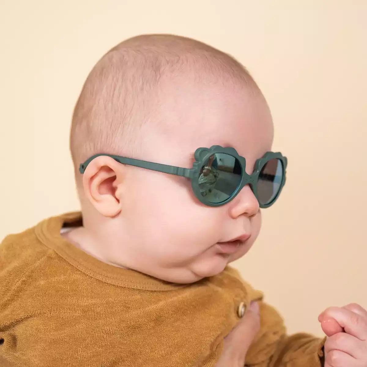 bébé portant lunette soleil lion vert
